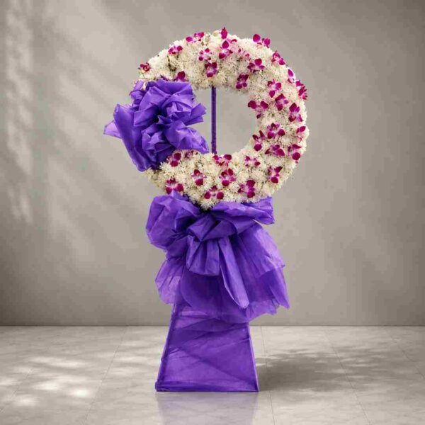 Cát bụi – vòng hoa chia buồn tông trắng tím thiết kế hình tròn sang trọng, thể hiện sự tiếc thương và tiễn biệt trang nghiêm