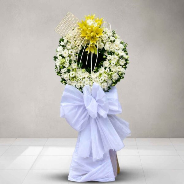 Kệ hoa chia buồn Lưu luyến tông trắng phối hoa ly vàng nổi bật, thiết kế vòng tròn sang trọng thể hiện sự tiếc thương và tiễn biệt.