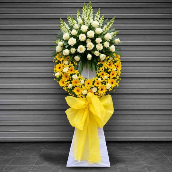 Vòng Hoa Đám Tang Hai Thế Giới 201 với thiết kế hoa trắng và vàng nổi bật, kết hợp hoa hồng trắng, hoa đồng tiền vàng cùng nơ lớn trang nhã thể hiện sự tiếc thương sâu sắc.