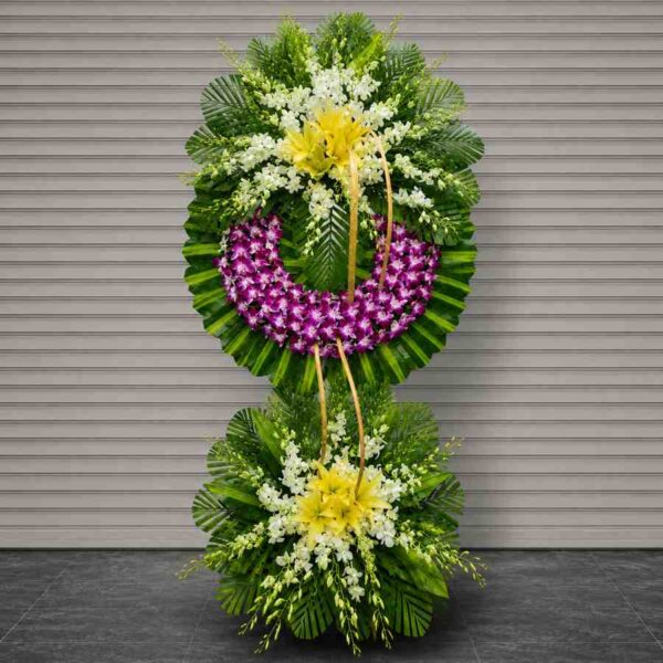 Kệ hoa chia buồn 039 với thiết kế hai tầng nổi bật từ hoa lan tím, ly vàng và hoa trắng sang trọng trên nền lá xanh hiện đại.
