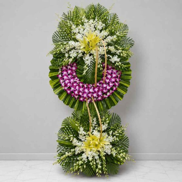 Kệ hoa chia buồn 039 với thiết kế hai tầng nổi bật từ hoa lan tím, ly vàng và hoa trắng sang trọng trên nền lá xanh hiện đại.