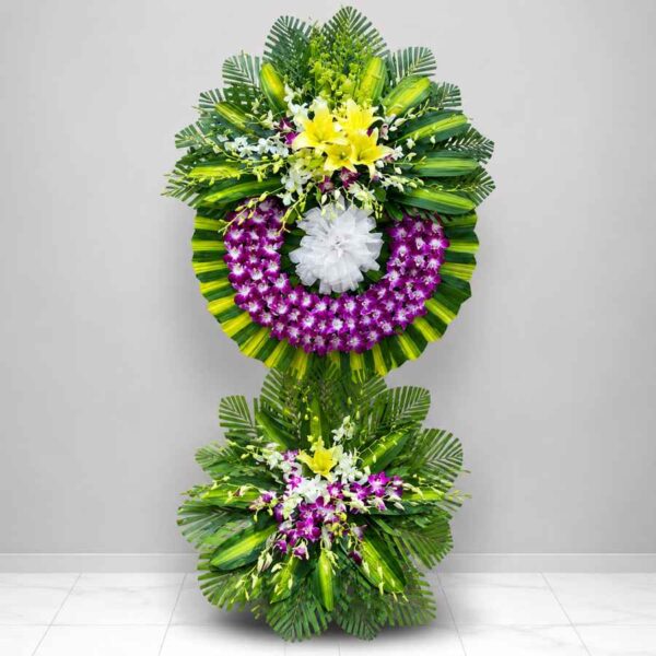 Kệ hoa chia buồn 040 nổi bật với vòng hoa lan tím kết hợp hoa ly vàng và lá xanh sang trọng, thiết kế hiện đại hai tầng.