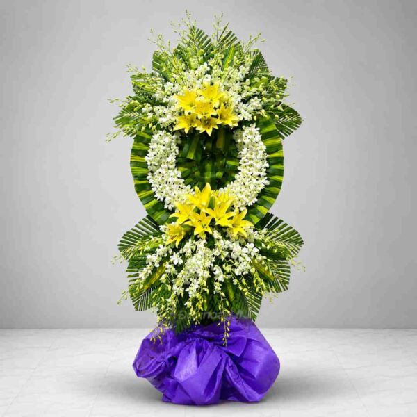 Kệ hoa chia buồn 035 với vòng hoa lan trắng kết hợp hoa ly vàng nổi bật, thiết kế hai tầng sang trọng trên nền lá xanh nghệ thuật, thể hiện sự tiếc thương và lòng thành kính sâu sắc.