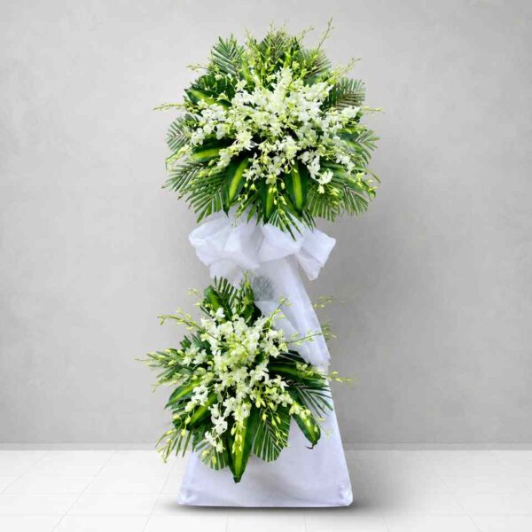 Kệ Hoa Viếng Tiễn Biệt 019 với hoa lan trắng sang trọng kết hợp lá xanh tươi, thiết kế hai tầng trang nhã thể hiện lòng tiếc thương và sự chia buồn chân thành.