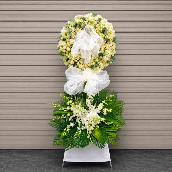Kệ hoa chia buồn Tiễn Biệt 22 với vòng hoa hồng trắng sang trọng kết hợp lan trắng và lá xanh hiện đại.