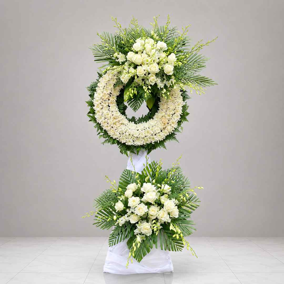 Kệ chia buồn cúc trắng 02 1 Kệ chia buồn cúc trắng 02 với vòng hoa cúc trắng kết hợp hoa hồng trắng và lá xanh trang nhã, thiết kế hai tầng sang trọng và trang nghiêm.