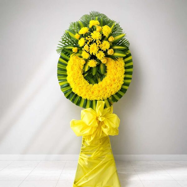 Kệ chia buồn cúc vàng với hoa cúc vàng rực rỡ, lá xanh nổi bật và thiết kế vòng hoa viếng trang trọng