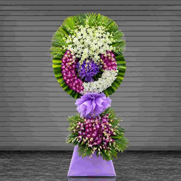 Kệ chia buồn tiễn biệt 407 với hoa lan trắng và lan tím cao cấp, thiết kế vòng hoa tròn sang trọng kết hợp nơ tím nổi bật, thể hiện sự kính trọng và tiếc thương sâu sắc.