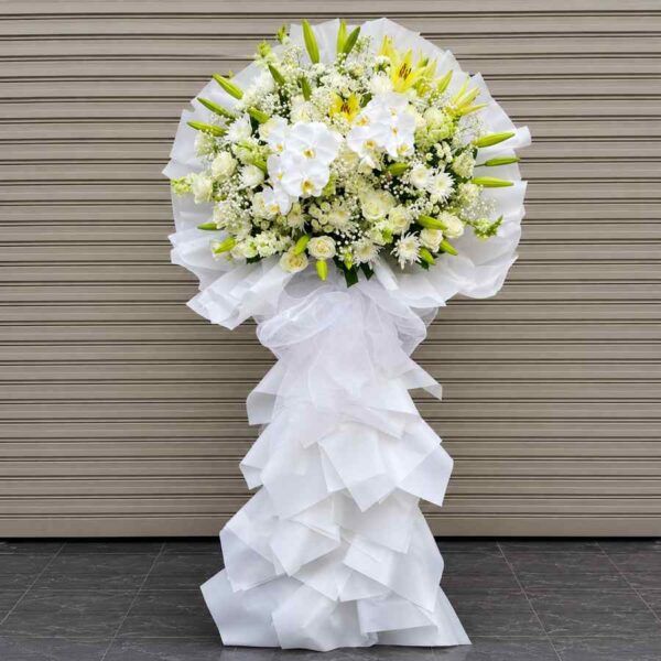 Kệ chia buồn tiễn biệt 419 với hoa lan hồ điệp trắng, ly vàng và hoa hồng trắng sang trọng trên thiết kế hiện đại.