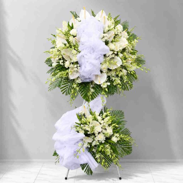 Kệ chia buồn tiễn biệt 606 với thiết kế hai tầng hoa trắng sang trọng, kết hợp hoa ly, hoa hồng và lá xanh tạo vẻ trang nghiêm, tinh tế.