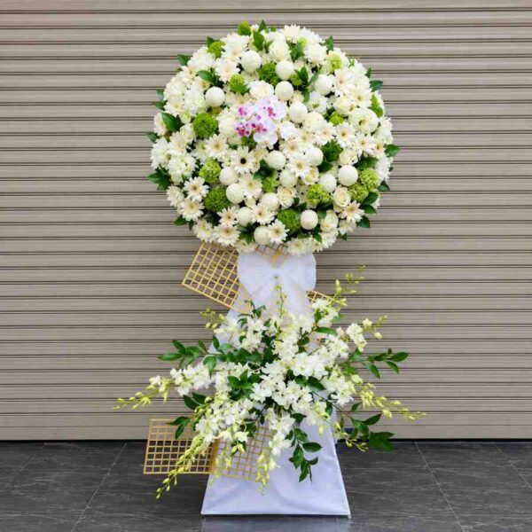 Kệ hoa chia buồn 402 với vòng hoa trắng sang trọng kết hợp lan trắng và điểm nhấn lan tím nhẹ nhàng trên thiết kế hiện đại.