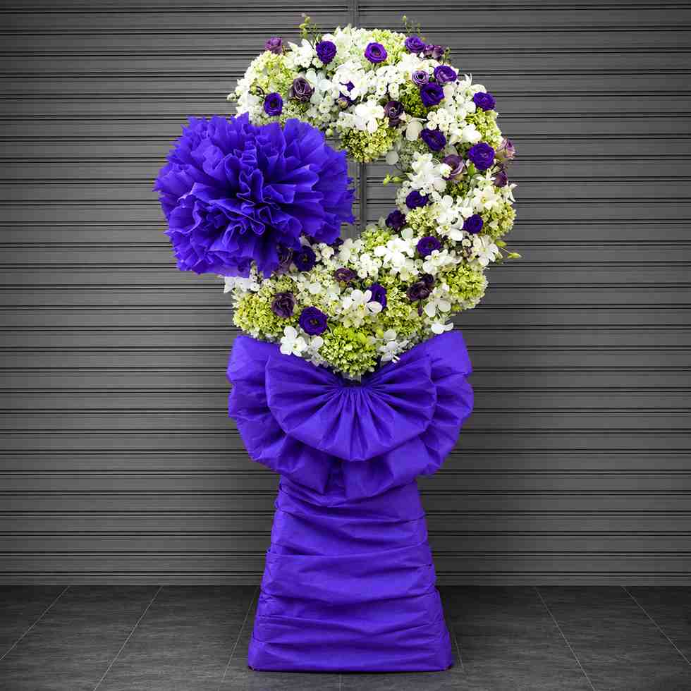 Hoa chia buồn 905 2 Hoa chia buồn 905 với vòng hoa tông trắng tím nổi bật, kết hợp nơ tím sang trọng và thiết kế kệ cao cân đối, trang nghiêm