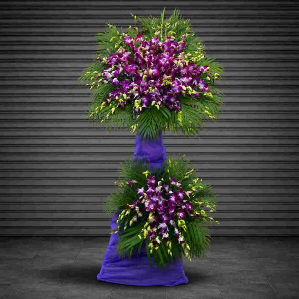 Hoa chia buồn 907 với lan tím nổi bật kết hợp lá cau xanh, thiết kế hai tầng sang trọng thể hiện sự kính trọng và lời chia buồn sâu sắc.