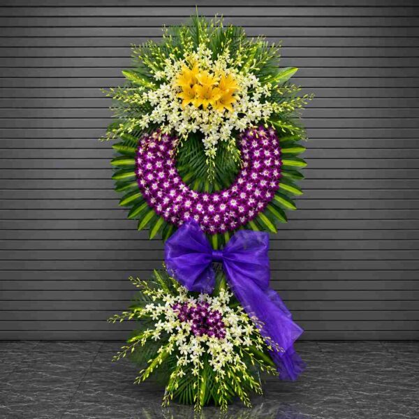 Kệ hoa chia buồn 128 với vòng hoa lan tím nổi bật kết hợp hoa lan trắng, ly vàng và lá xanh nghệ thuật, thiết kế sang trọng dành cho lễ viếng và tưởng niệm.