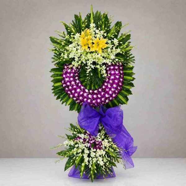 Kệ hoa chia buồn 128 với vòng hoa lan tím nổi bật kết hợp hoa lan trắng, ly vàng và lá xanh nghệ thuật, thiết kế sang trọng dành cho lễ viếng và tưởng niệm.
