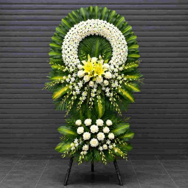 Kệ hoa chia buồn 137 với vòng lan trắng, hoa ly vàng và hoa hồng trắng sang trọng, thiết kế trang nghiêm thể hiện lòng thành kính và tiếc thương sâu sắc.