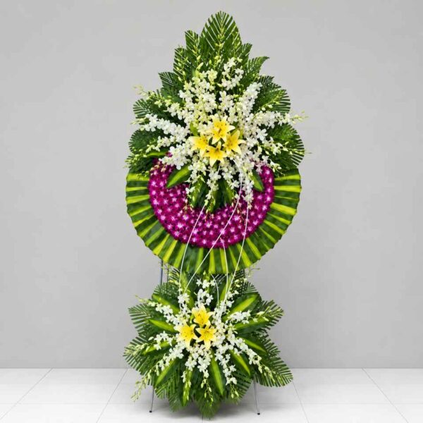 Kệ hoa chia buồn 127 nổi bật với hoa lan tím, hoa ly vàng và hoa trắng kết hợp cùng lá xanh nghệ thuật, thiết kế sang trọng thể hiện lòng tiếc thương sâu sắc.