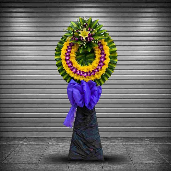 Kệ hoa chia buồn 190 với vòng hoa vàng tím sang trọng, nổi bật trên nền lá xanh, phù hợp gửi lời tiễn biệt trang trọng