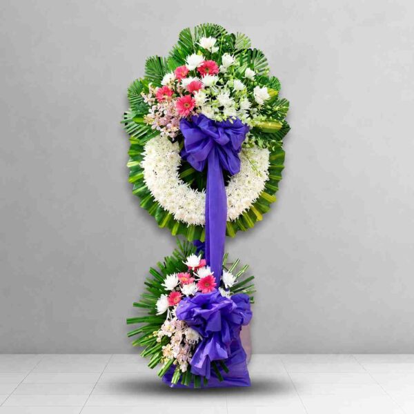 Kệ hoa chia buồn 209 tông trắng phối hoa hồng phấn, vòng hoa tang lễ sang trọng kèm nơ tím nổi bật