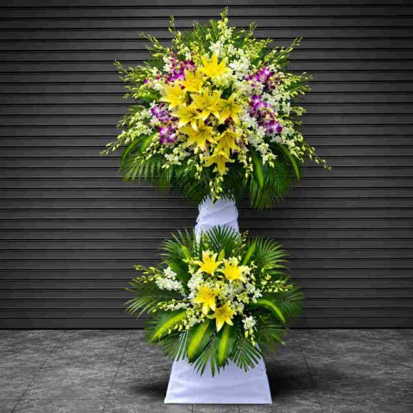 : Kệ hoa chia buồn 214 tông vàng trắng nổi bật với hoa ly vàng, lan trắng và hoa tím sang trọng, thiết kế trang nghiêm cho lễ viếng