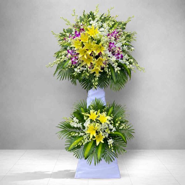 : Kệ hoa chia buồn 214 tông vàng trắng nổi bật với hoa ly vàng, lan trắng và hoa tím sang trọng, thiết kế trang nghiêm cho lễ viếng