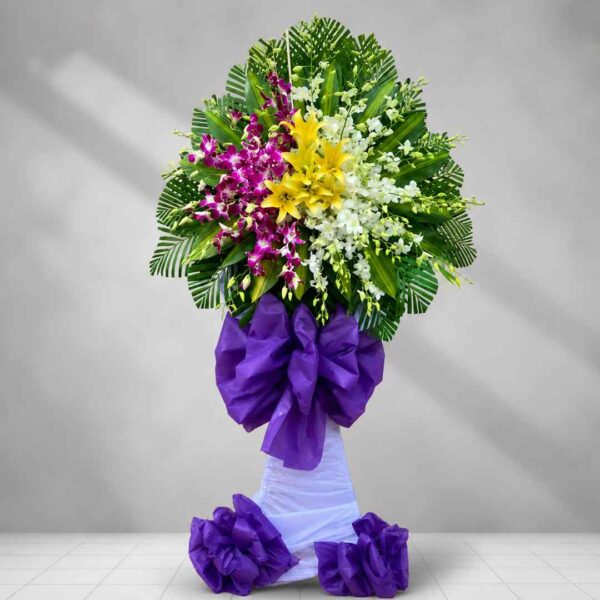 Kệ hoa chia buồn 215 với hoa lan tím, hoa ly vàng và lan trắng nổi bật, thiết kế trang trọng dành cho lễ viếng