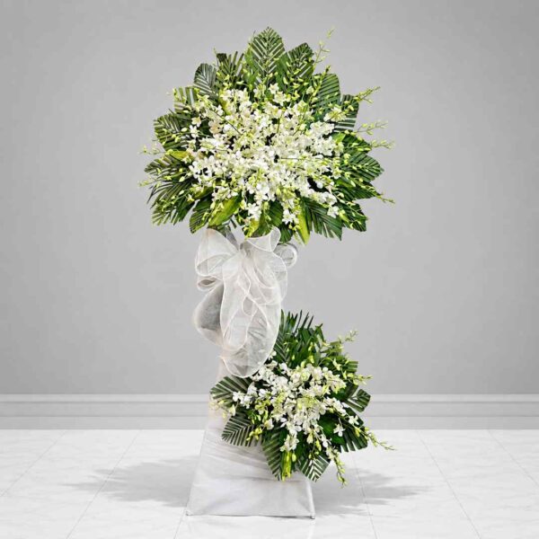 Kệ hoa chia buồn 304 với thiết kế hai tầng hoa lan trắng cao cấp kết hợp lá xanh trang trí, mang vẻ đẹp trang nghiêm, thanh lịch và thể hiện lòng thành kính sâu sắc.