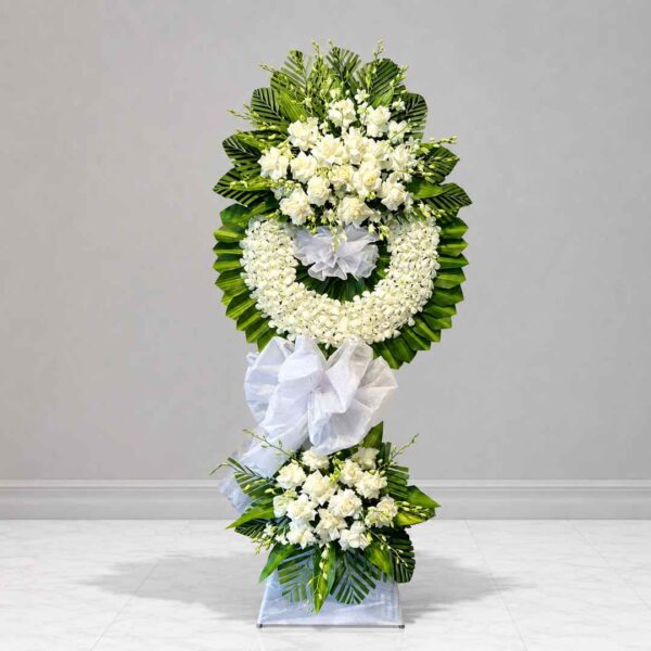 Kệ hoa chia buồn 308 với thiết kế vòng hoa trắng sang trọng, kết hợp hoa hồng trắng, lan trắng và lá xanh cao cấp, thể hiện lòng thành kính và sự tiếc thương sâu sắc.
