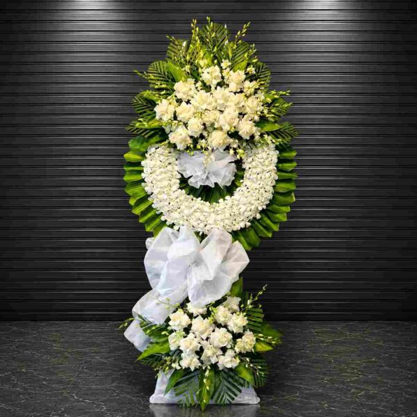Kệ hoa chia buồn 308 với thiết kế vòng hoa trắng sang trọng, kết hợp hoa hồng trắng, lan trắng và lá xanh cao cấp, thể hiện lòng thành kính và sự tiếc thương sâu sắc.