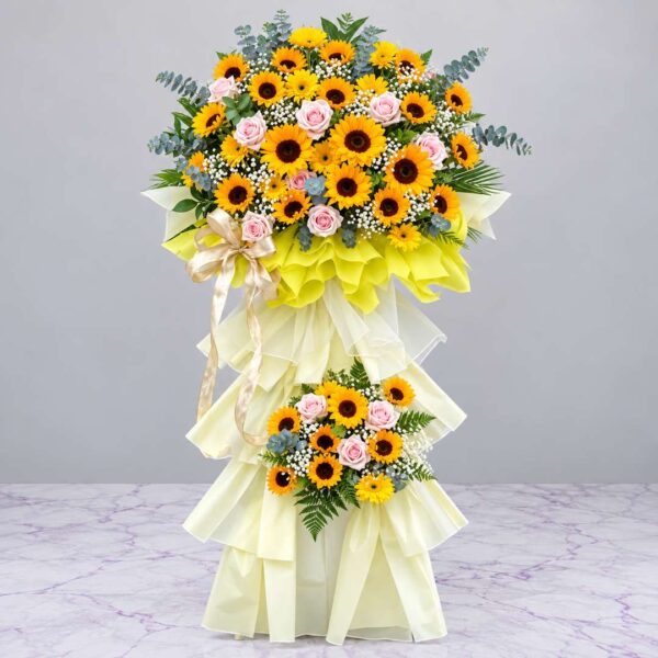 Kệ hoa khai trương Nhật Dương Cát Tường với hoa hướng dương vàng, hoa hồng pastel và giấy gói vàng kem sang trọng.
