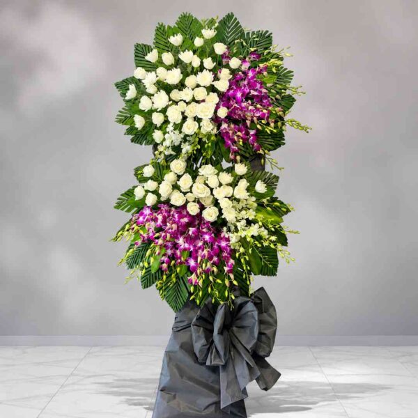 Kệ hoa chia buồn 309 phối hoa hồng trắng và lan tím sang trọng, thiết kế hai tầng nổi bật thể hiện sự kính trọng và tiếc thương sâu sắc