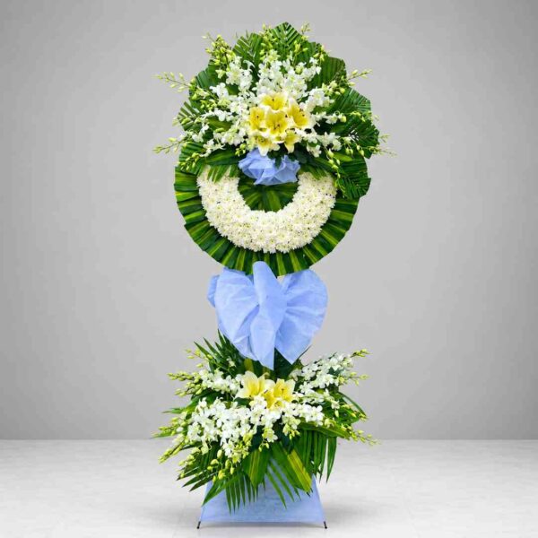 Kệ hoa chia buồn 327 với vòng hoa cúc trắng kết hợp hoa ly vàng, lan trắng và lá xanh nghệ thuật, thiết kế trang trọng dành cho lễ viếng và tưởng niệm.
