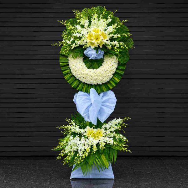 Kệ hoa chia buồn 327 với vòng hoa cúc trắng kết hợp hoa ly vàng, lan trắng và lá xanh nghệ thuật, thiết kế trang trọng dành cho lễ viếng và tưởng niệm.