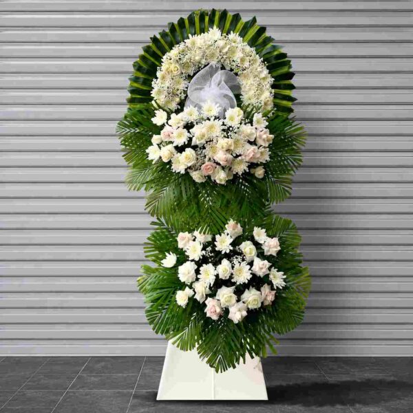 Kệ hoa chia buồn 333 tone trắng sang trọng với hoa hồng trắng, cúc trắng kết hợp lá xanh, thiết kế hai tầng trang nghiêm dành cho lễ tang.