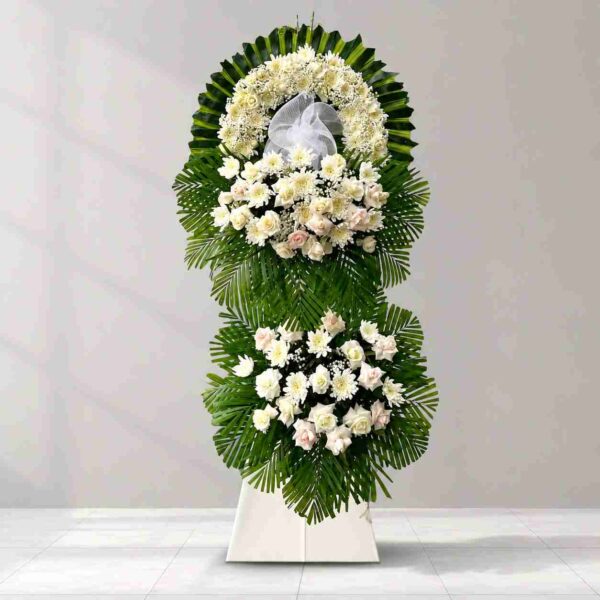 Kệ hoa chia buồn 333 tone trắng sang trọng với hoa hồng trắng, cúc trắng kết hợp lá xanh, thiết kế hai tầng trang nghiêm dành cho lễ tang.