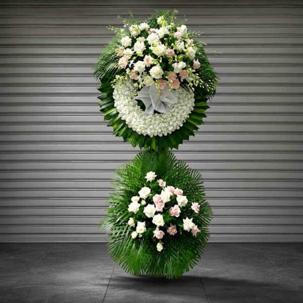 Kệ hoa chia buồn 336 tông trắng thanh lịch với vòng hoa trắng kết hợp hoa hồng trắng, hồng phấn và lá xanh sang trọng.