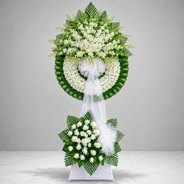 Kệ hoa chia buồn 352 với vòng hoa trắng cao cấp kết hợp lan trắng, hoa hồng trắng và lá xanh nổi bật, thiết kế hai tầng trang trọng thể hiện lòng thành kính và sự tiếc thương sâu sắc.