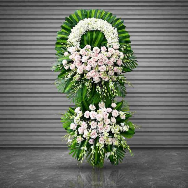 Kệ hoa chia buồn 357 tone trắng hồng sang trọng với hoa hồng pastel, lan trắng và lá xanh nổi bật thiết kế hai tầng hiện đại