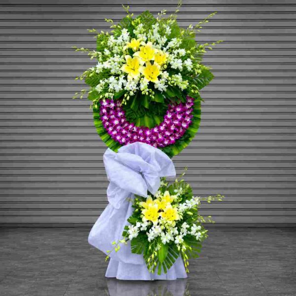 Kệ hoa chia buồn 359 với hoa lan tím, ly vàng và hoa trắng thiết kế sang trọng nổi bật trên nền lá xanh hiện đại
