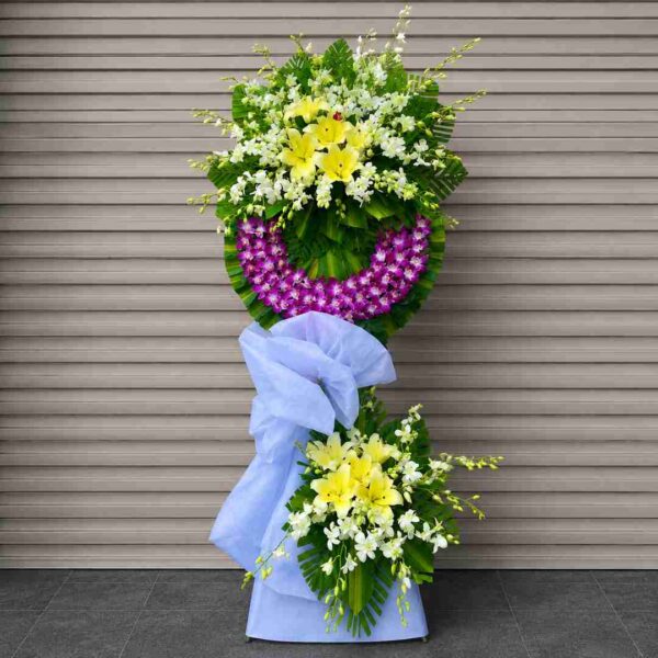 Hoa Chia Buồn An Yên Miền Cực Lạc 349 với hoa lan tím, ly vàng và hoa trắng kết hợp hài hòa, thiết kế sang trọng thể hiện sự tiếc thương và lời tiễn biệt trang nghiêm.