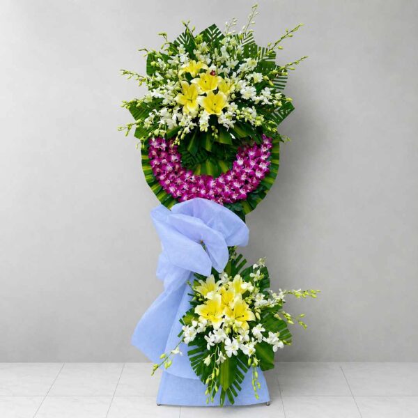 Hoa Chia Buồn An Yên Miền Cực Lạc 349 với hoa lan tím, ly vàng và hoa trắng kết hợp hài hòa, thiết kế sang trọng thể hiện sự tiếc thương và lời tiễn biệt trang nghiêm.