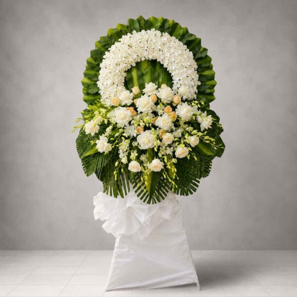 Kệ hoa chia buồn 326 với hoa lan trắng, hoa hồng kem và lá xanh nghệ thuật, thiết kế sang trọng cho lễ viếng