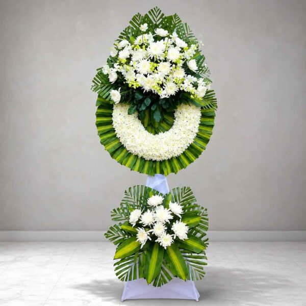 Kệ hoa chia buồn 328 tông trắng xanh sang trọng với vòng hoa cúc trắng kết hợp lá xanh nghệ thuật, thiết kế trang nghiêm và tinh tế