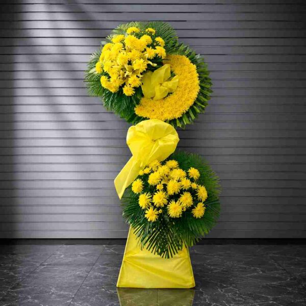 Kệ hoa chia buồn 335 với tông vàng nổi bật từ hoa cúc vàng kết hợp lá xanh nghệ thuật, mang ý nghĩa tưởng nhớ và lời tiễn biệt trang trọng.