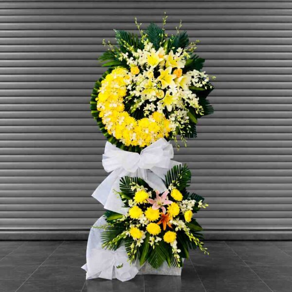 Hoa Viếng Tang Lễ Kính Thương 373 – kệ hoa viếng tang 2 tầng tông vàng trắng sang trọng, kết hợp hoa ly, cúc và lan thể hiện sự kính tiếc, chia buồn sâu sắc.