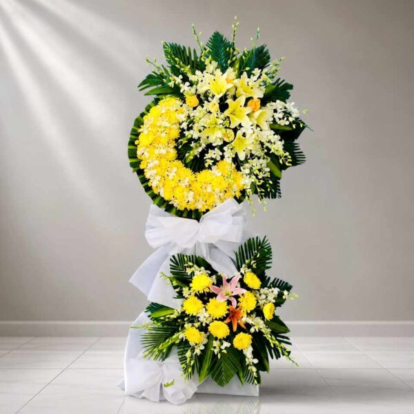 Hoa Viếng Tang Lễ Kính Thương 373 – kệ hoa viếng tang 2 tầng tông vàng trắng sang trọng, kết hợp hoa ly, cúc và lan thể hiện sự kính tiếc, chia buồn sâu sắc.