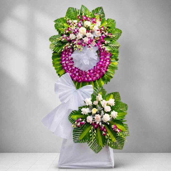 Kệ hoa chia buồn 361 với vòng lan tím nổi bật kết hợp hoa hồng kem và lá xanh nghệ thuật, thiết kế sang trọng và trang nghiêm