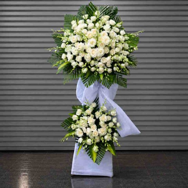 Kệ hoa chia buồn 424 với hoa hồng trắng cao cấp kết hợp lá xanh nghệ thuật, thiết kế hai tầng sang trọng thể hiện sự kính trọng và tiếc thương sâu sắc.
