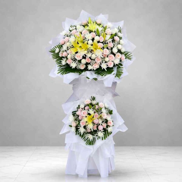 Kệ hoa chia buồn 426 với hoa ly vàng, hoa hồng phấn và hoa trắng cao cấp, thiết kế hai tầng sang trọng thể hiện sự tiếc thương và lòng thành kính
