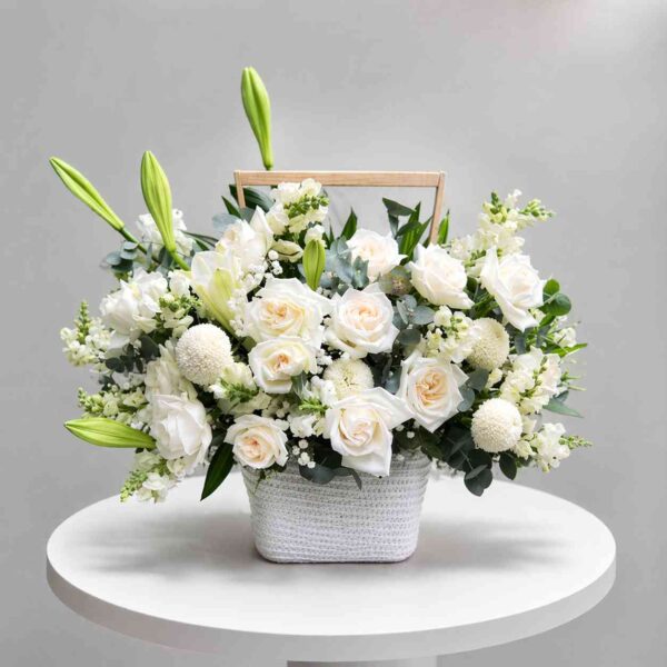 Giỏ hoa viếng 483 với hoa hồng trắng, hoa ly trắng và cúc trắng được cắm trong giỏ xách thanh lịch